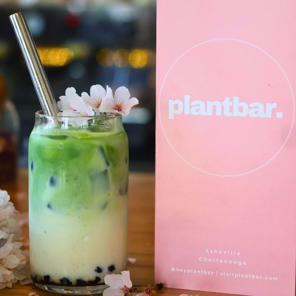 Iced matcha boba beside the Plant Bar menu
